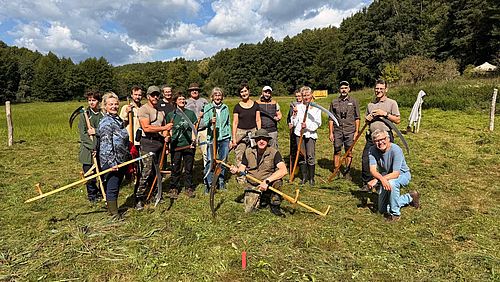 Gruppenbild der Teilnehmer des Sensenkurses 2026. Viele halten handwerkliche Sensen in den Händen.