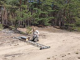 Vorbereitung zur Anbringung einer Niströhre für den Wiedehopf - ein Seil wird um das präparierte Holzhaus gelegt
