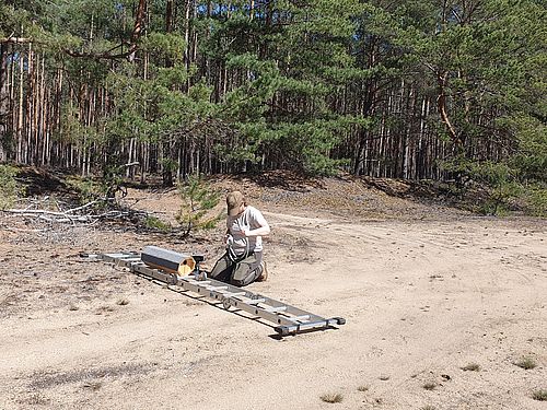 Vorbereitung zur Anbringung einer Niströhre für den Wiedehopf - ein Seil wird um das präparierte Holzhaus gelegt